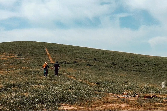 A shot from Samsung Iran's we're together video - a man and woman running hand in hand in a field